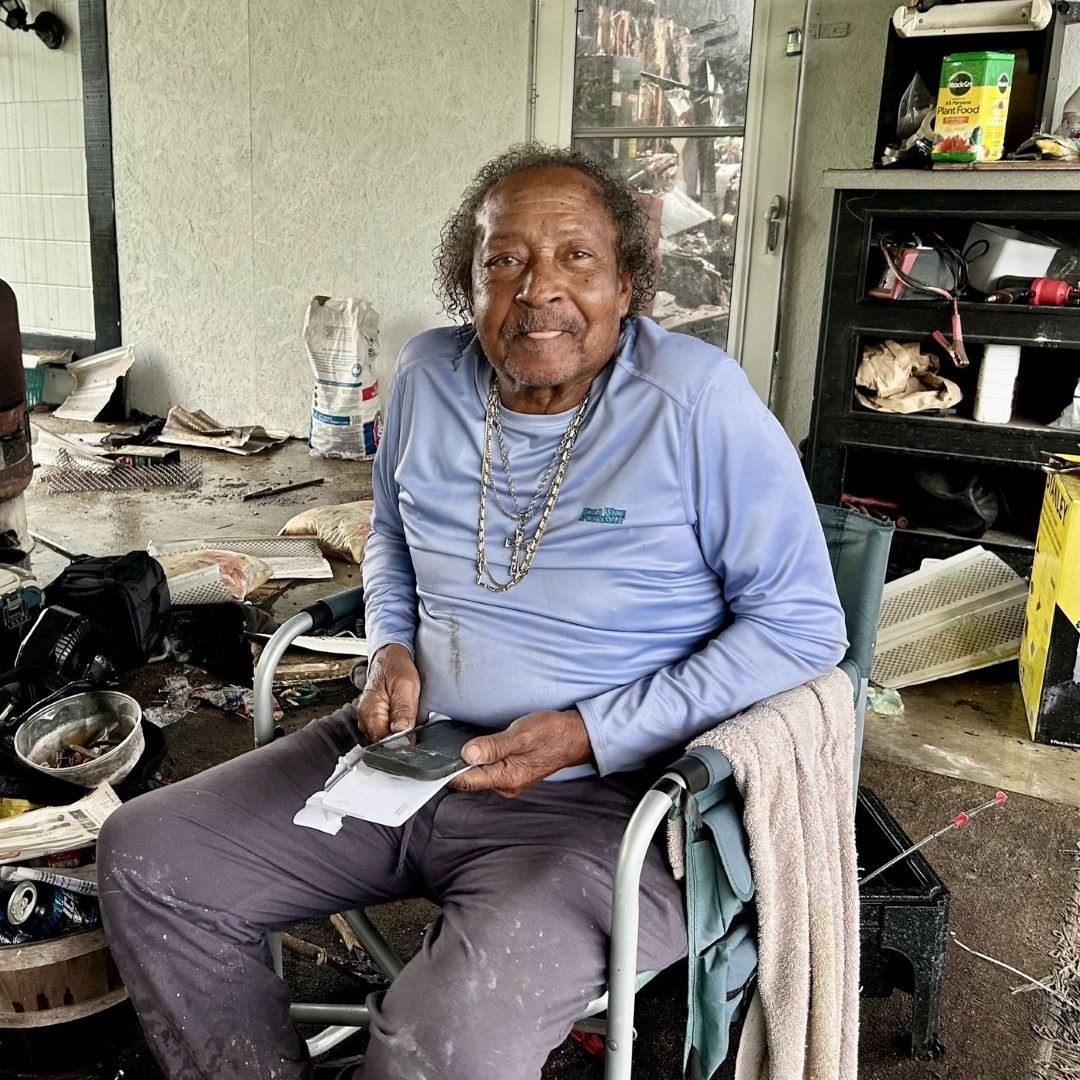 man sits in chair inside home