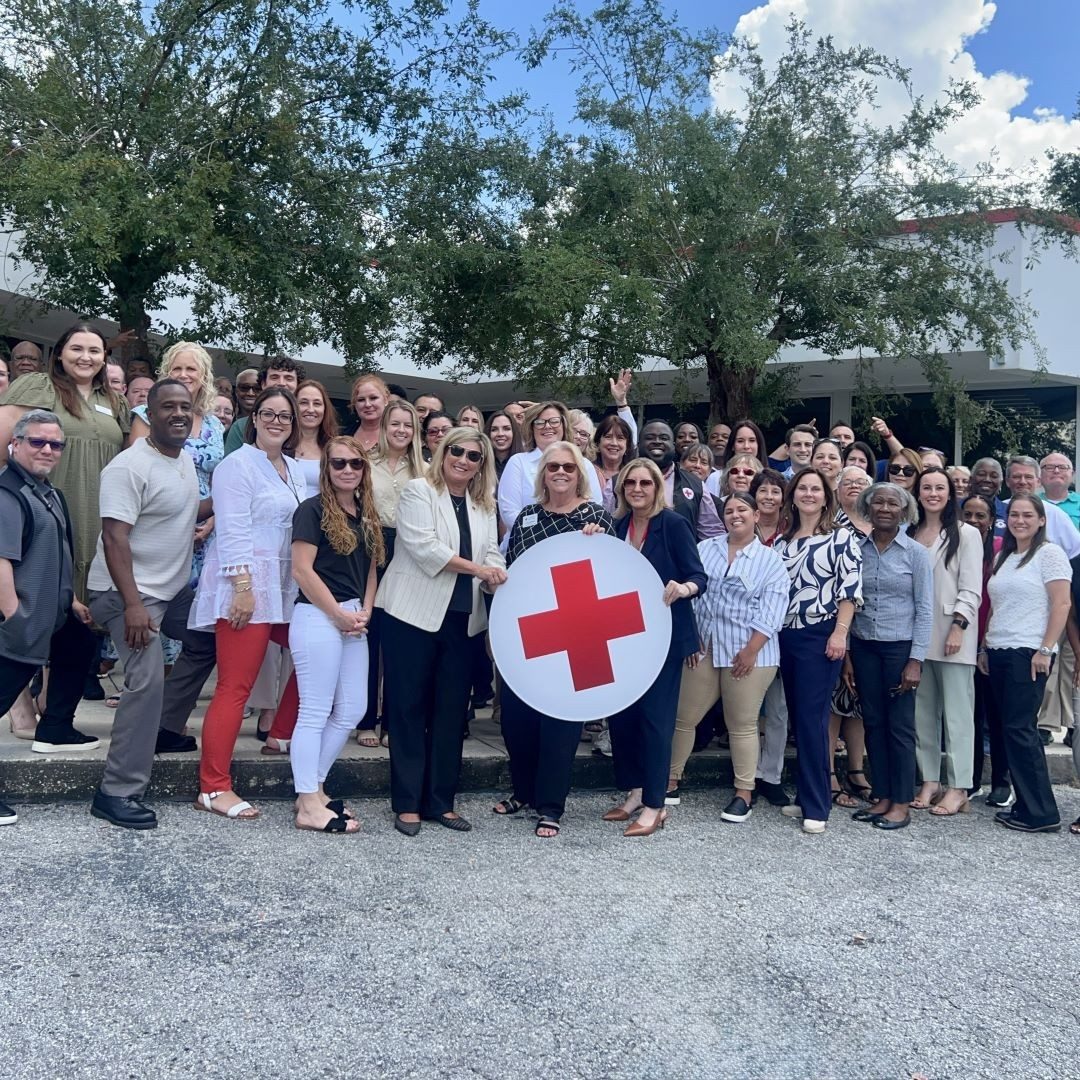 group of people behind red cross logo cutout 
