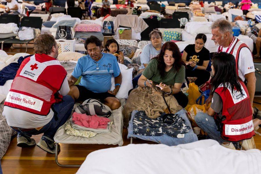 Arthur Valencia, his wife, Tara, and their three children speak with Red Cross staff members