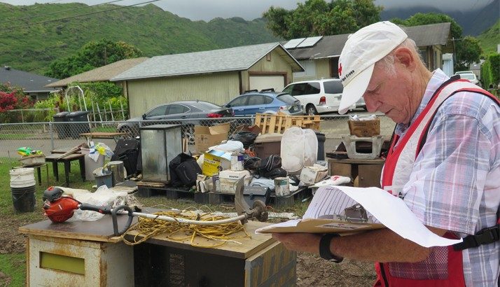 Red Cross volunteer in yard looking at clipboard