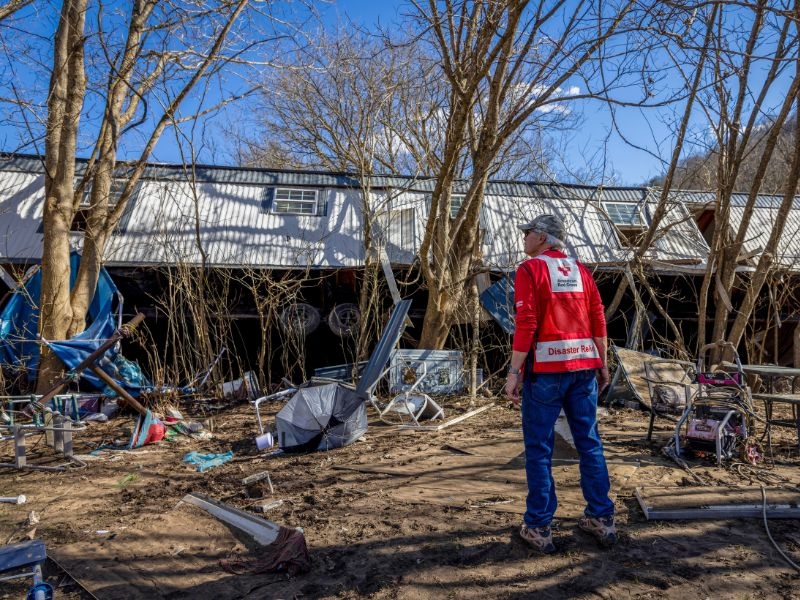 disaster volunteer viewing house damage from flooding
