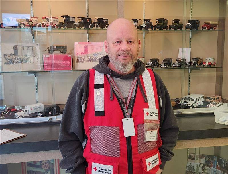 Man stands wearing Red Cross vest