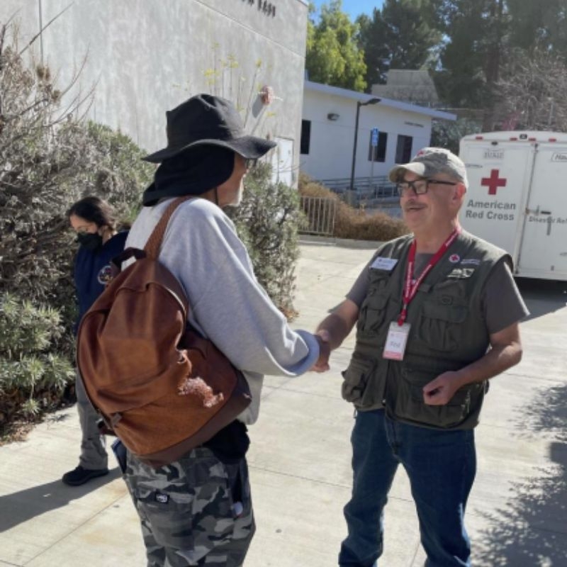 phil rehmer speaking with woman holding backpack