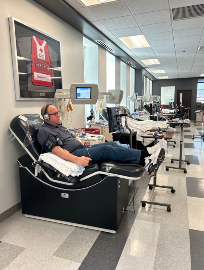 Man sits in blood donation chari donating blood