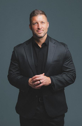 headshot of tim tebow in black tuxedo