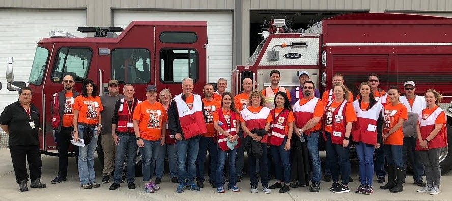 Group photo of American Red Cross volunteers standing in front of a Fire Engine.