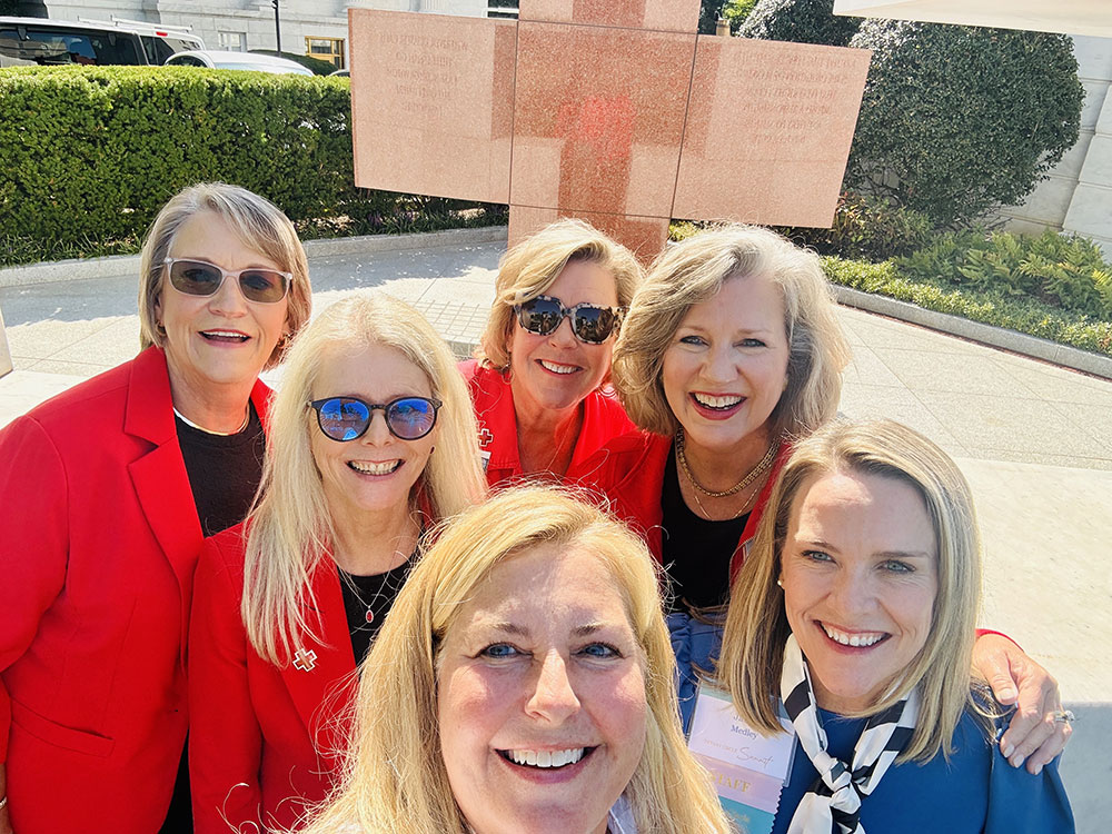 Six Tiffany Circle members in business clothing, with three of them wearing sunglasses, take a group photo outside.