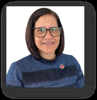 photo of woman in blue sweater with a red cross pin