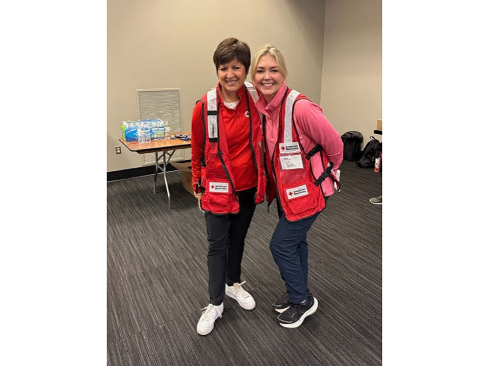Two Tiffany Circle members in Red Cross vests.