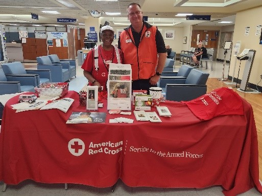 two red cross volunteers at a tabling event.
