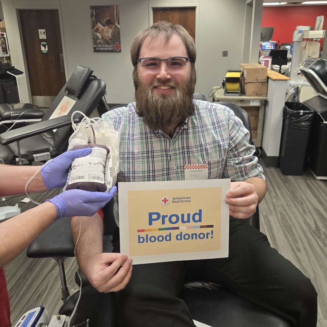 man holding proud blood donor sign 