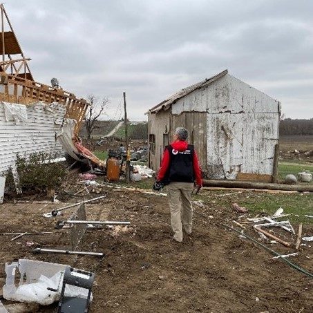 red cross volunteer observes tornado damage