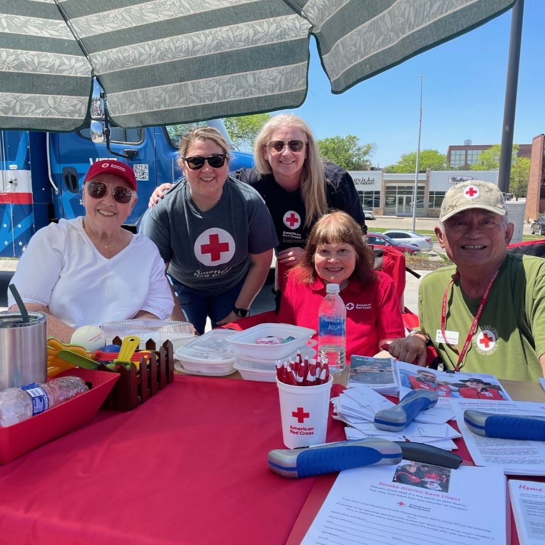 red cross volunteers sit behind table