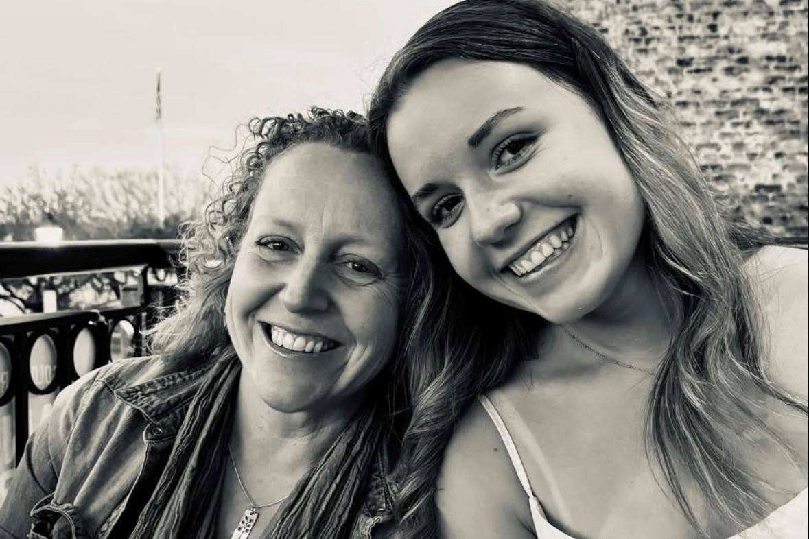 Mother and daughter smile next to one another