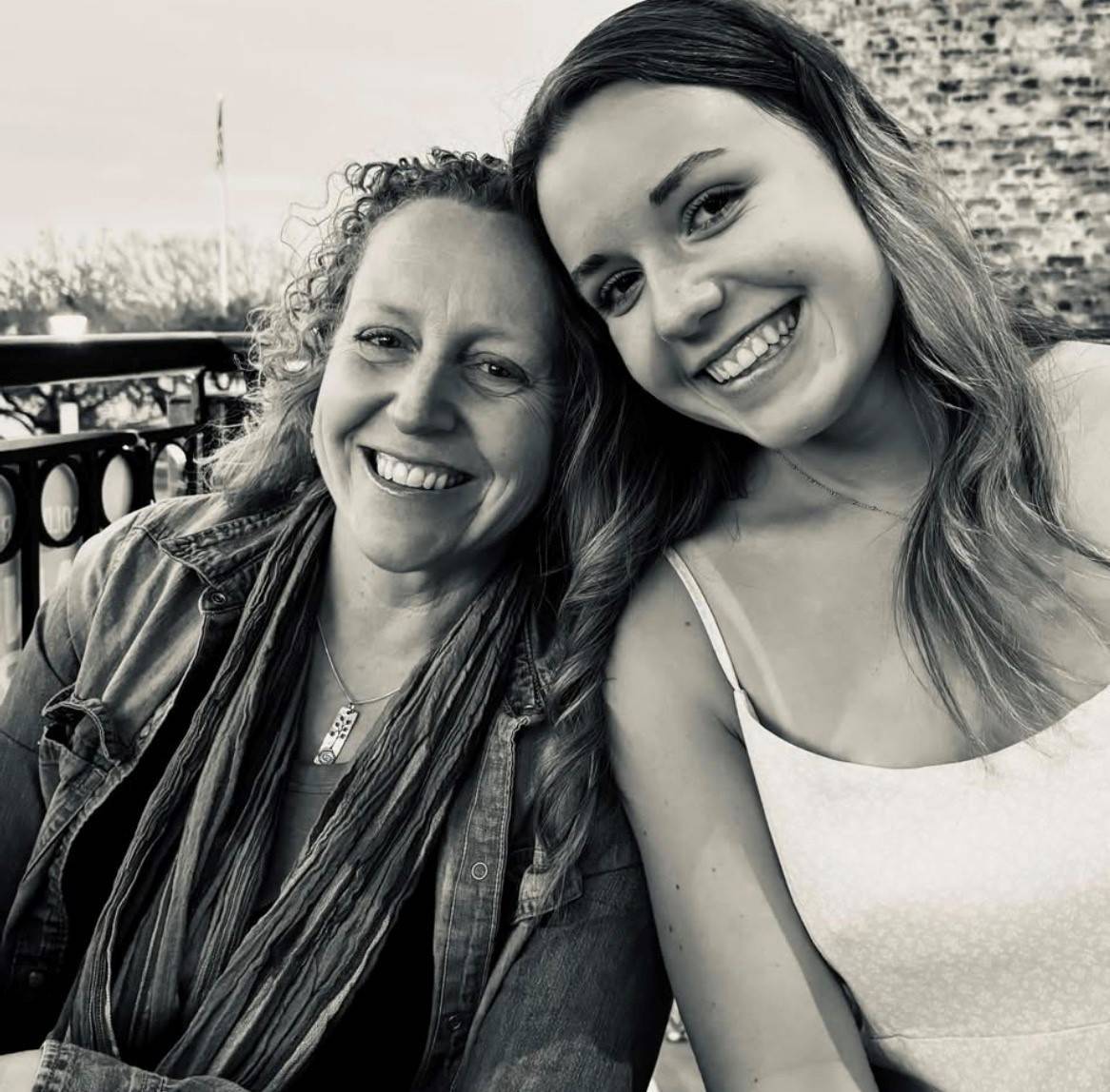Mother and daughter smile next to each other