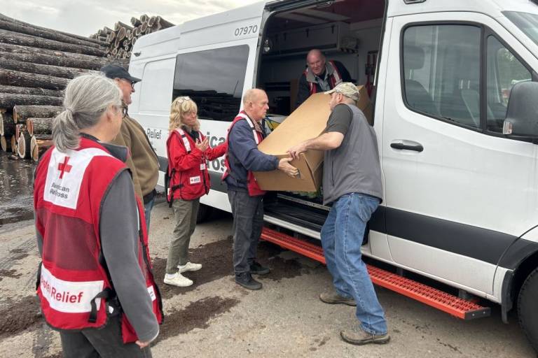 Group of Red Cross volunteers load large box into Emergency Response Vehicle