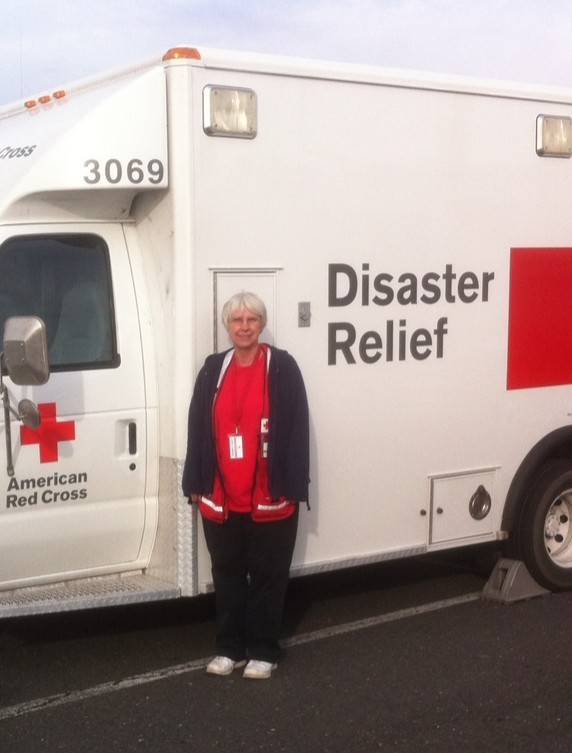 Woman stands in front of disaster relief vehicle