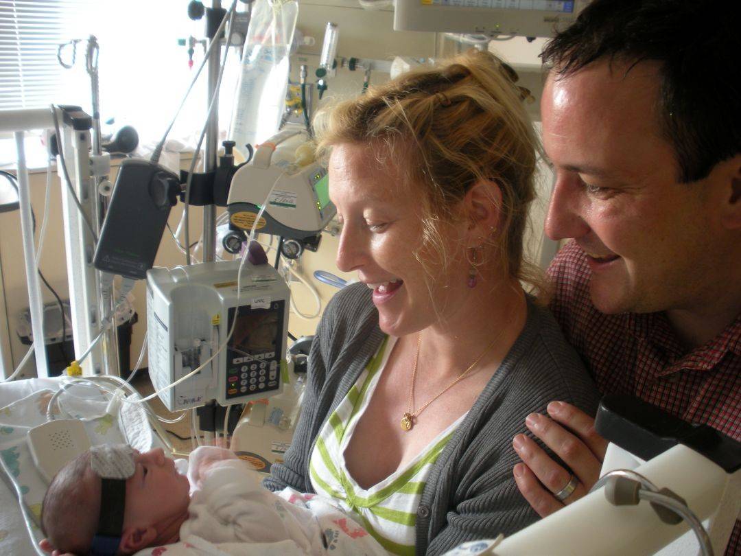 Parents hold newborn baby in hospital