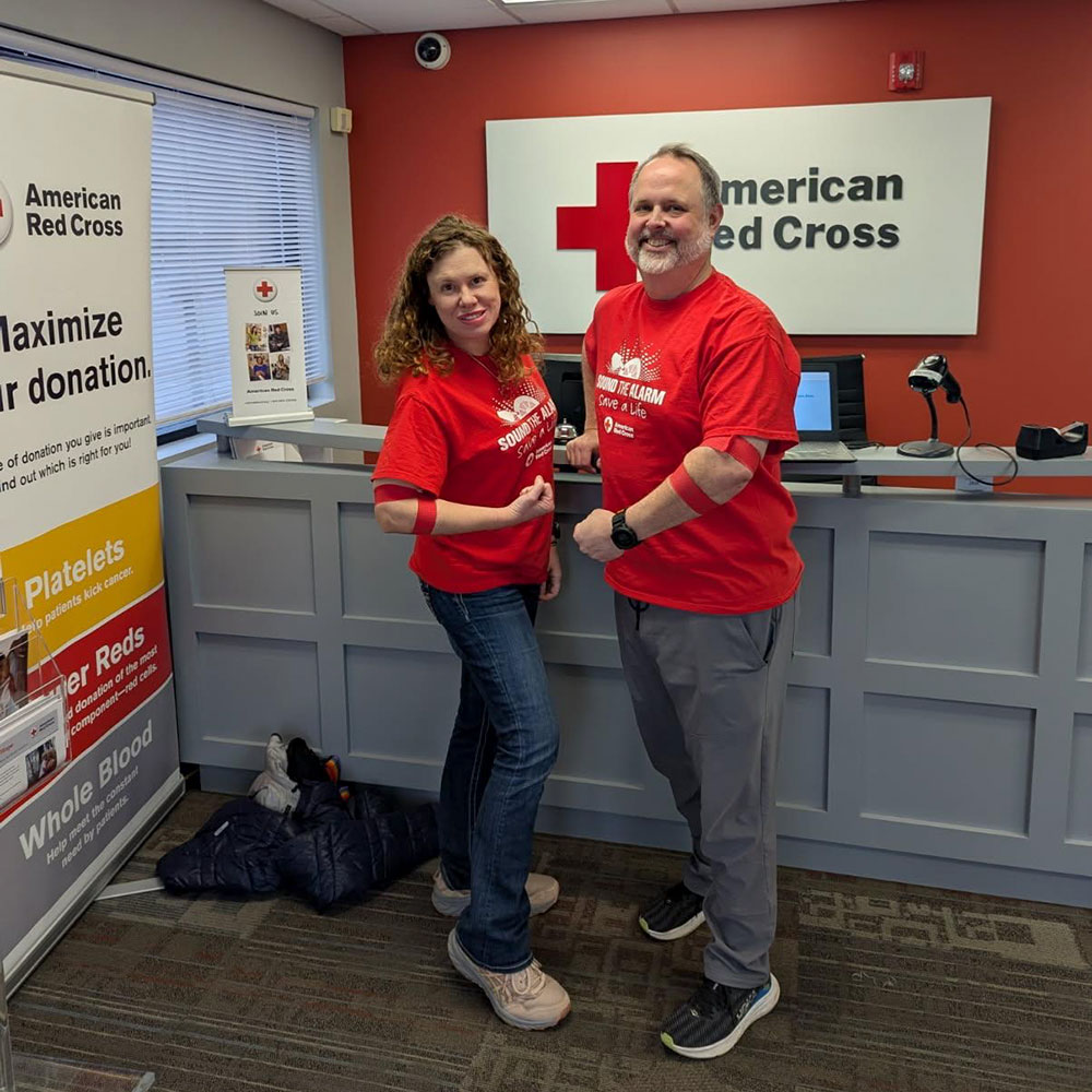 Shannon Pinegar and John Currie showing bandage around their arms after donating blood.