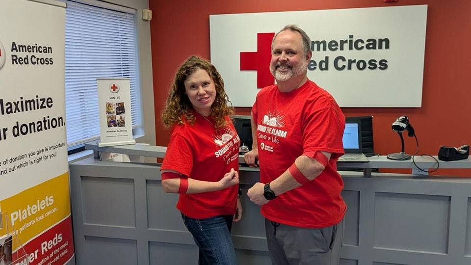 Shannon Pinegar and John Currie showing bandage around their arms after donating blood.
