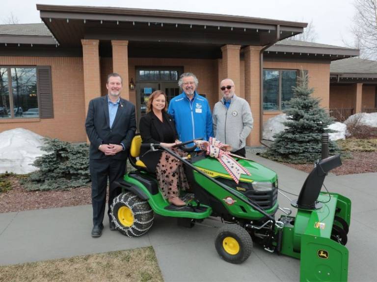 red crossers in front of fisher house with john deere tractor