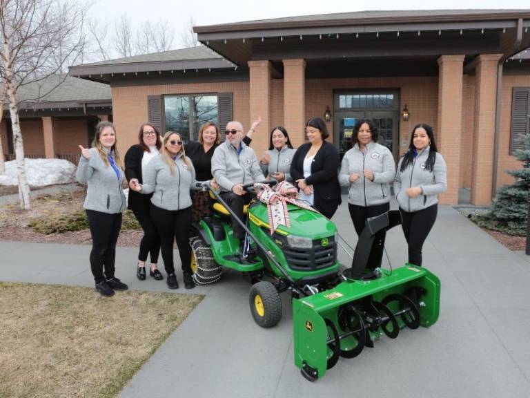 red crossers in front of fisher house with john deere tractor