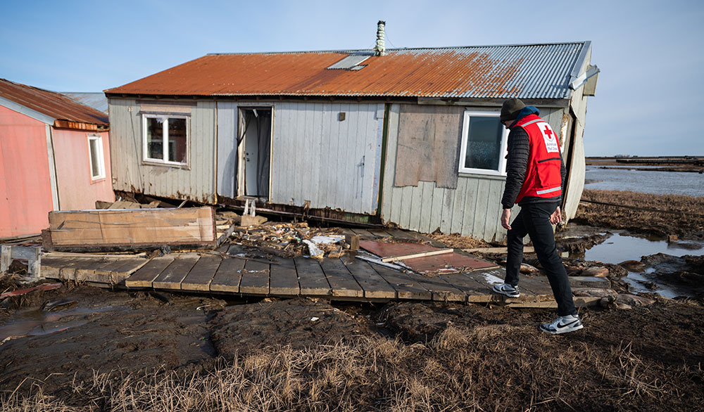 Red Crosser Dale Kunce walks through the heavily-damaged village of Kipnuk.
