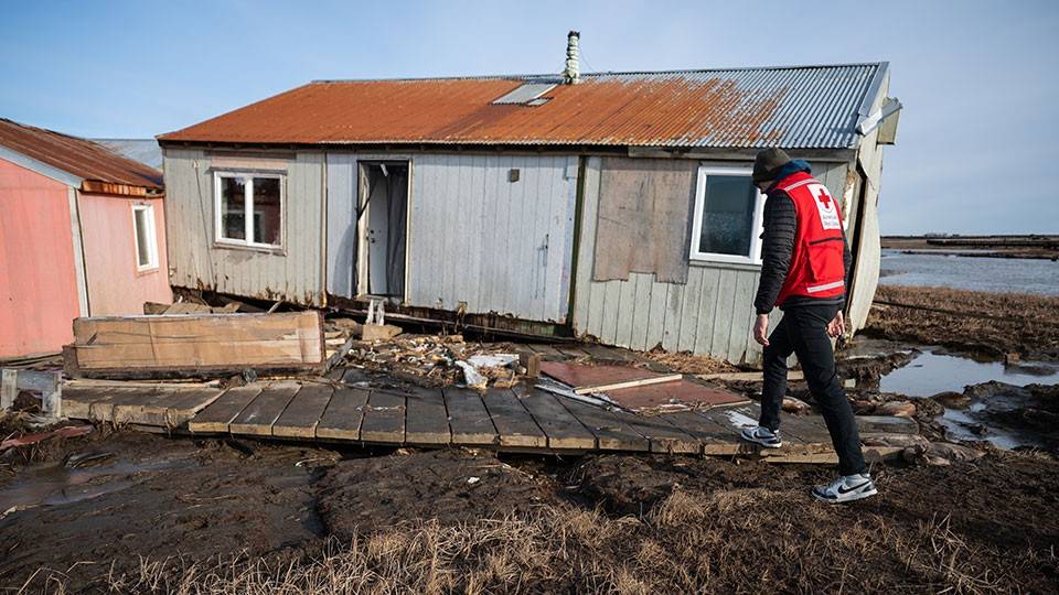 Red Crosser Dale Kunce walks through the heavily-damaged village of Kipnuk.