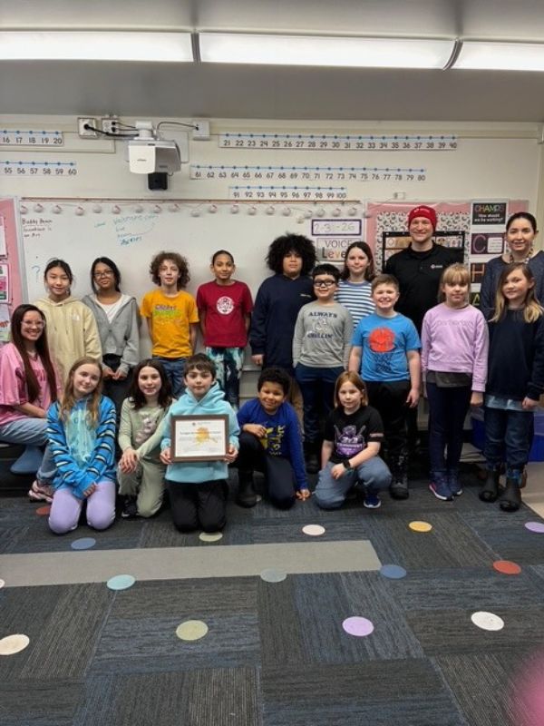 group of students in classroom holding certificate