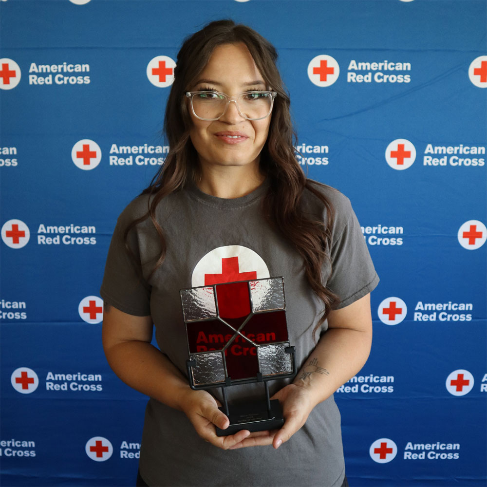 Red Cross volunteer Becca Havens holding the New Mexico Chapter’s Rookie of the Year Award at a red cross event.