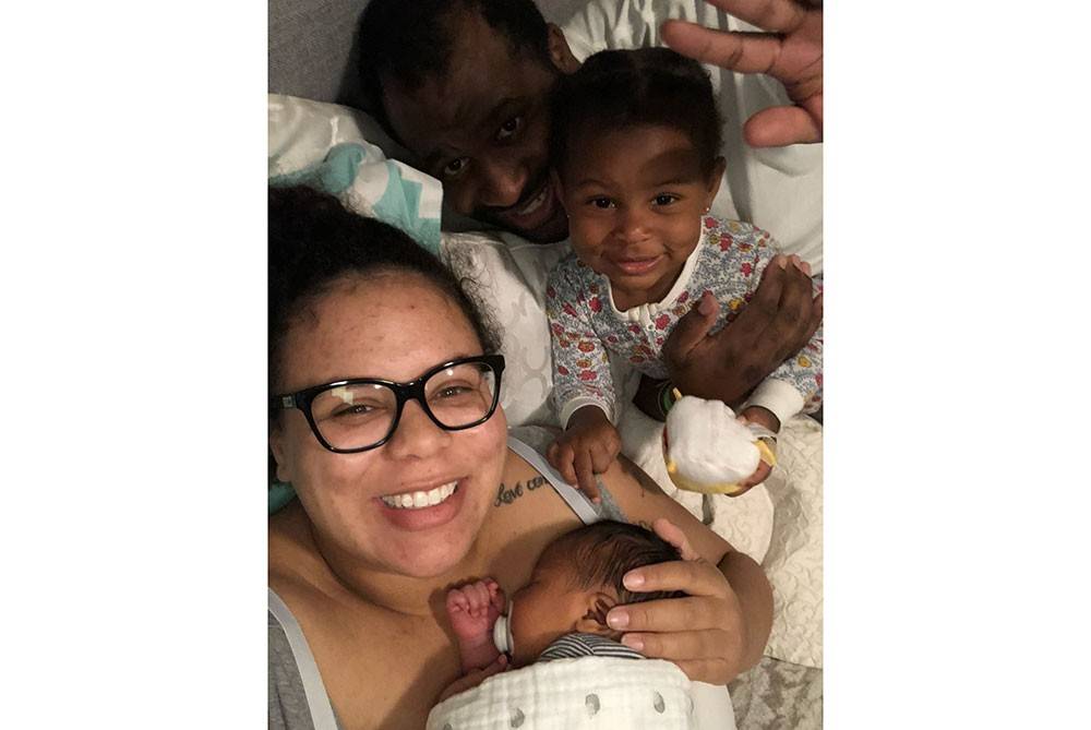 Angelena Fly holding her baby with her son and husband next to her.
