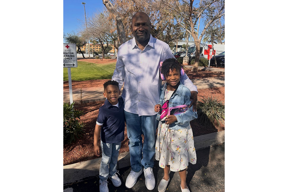 Angelena Fly's husband and two children outside on a sunny day.