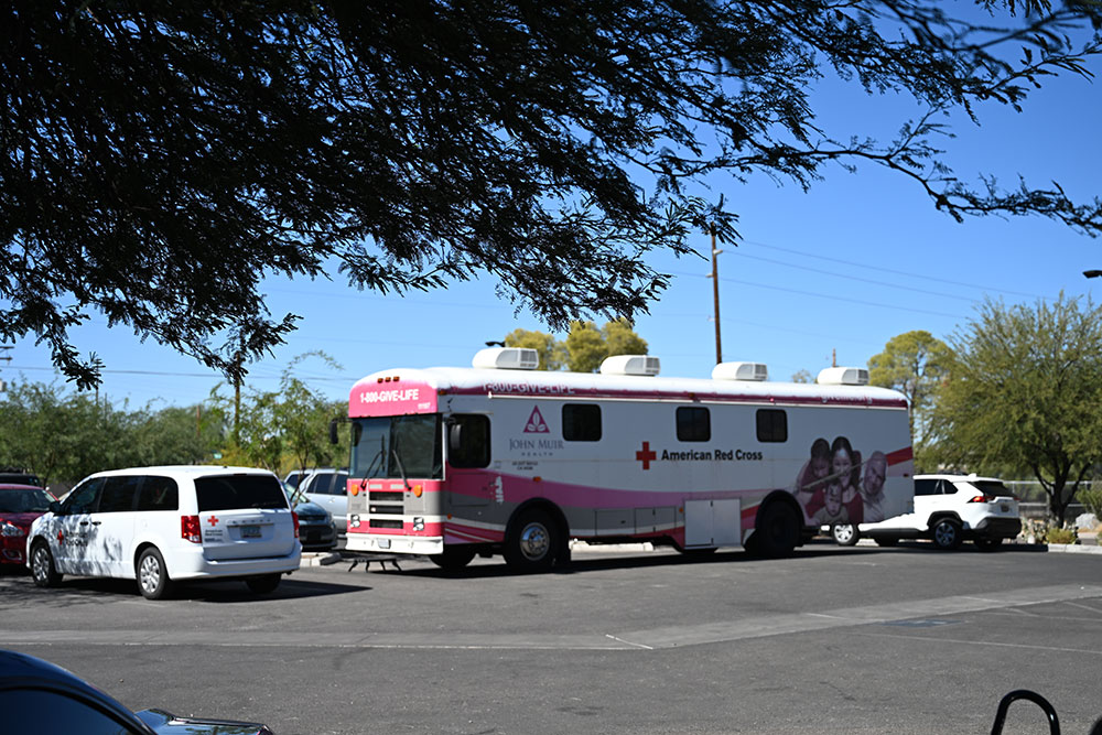 a red cross bloodmobile parked in a parking lot.