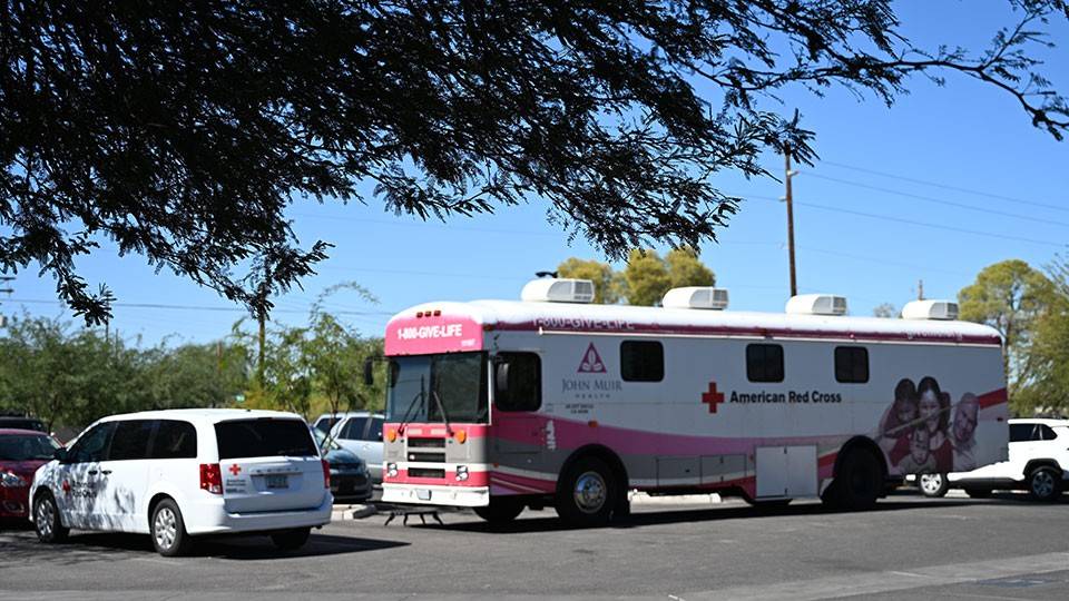a red cross bloodmobile parked in a parking lot.