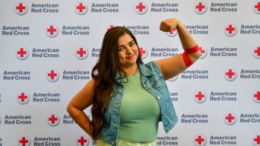 Janet Dubiel, the Blood Services Community Volunteer Leader for Northern Arizona, flexing arm that has a bandage on it.