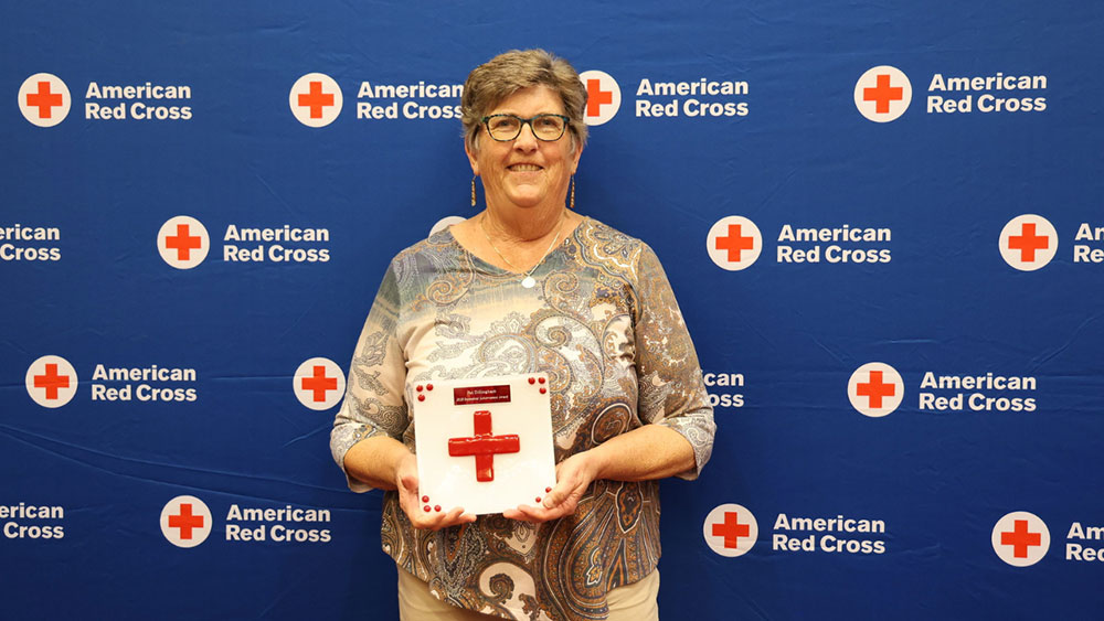 Pat Dillingham holding a Red Cross award at a Red Cross event.