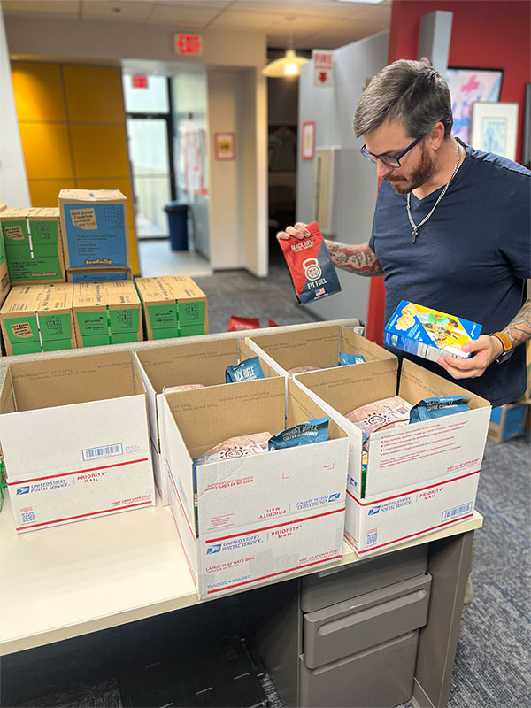 Justin Cavinder filling spirit-lifting packages with girl scout cookies for military service members.