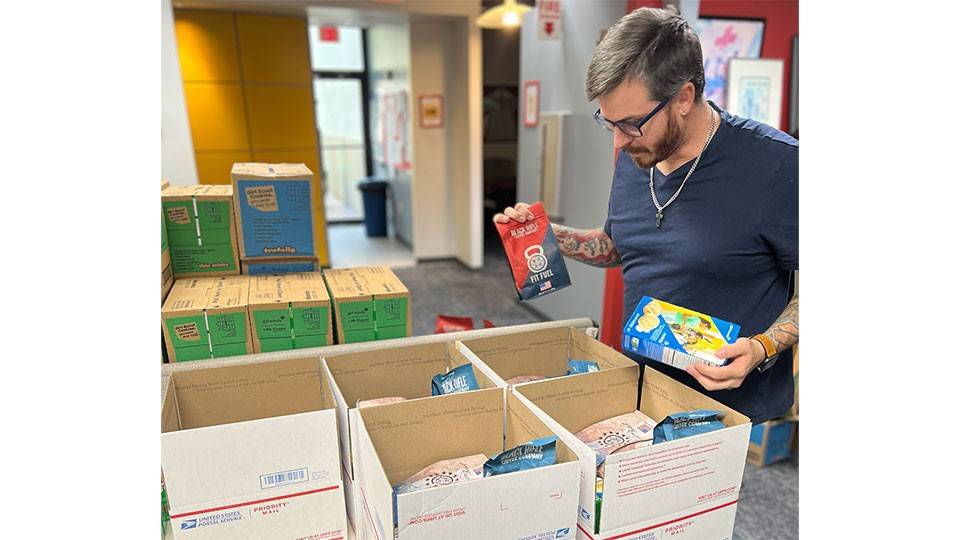 Justin Cavinder filling spirit-lifting packages with girl scout cookies for military service members.