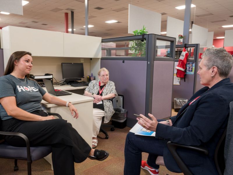 three red crossers in meeting in office.