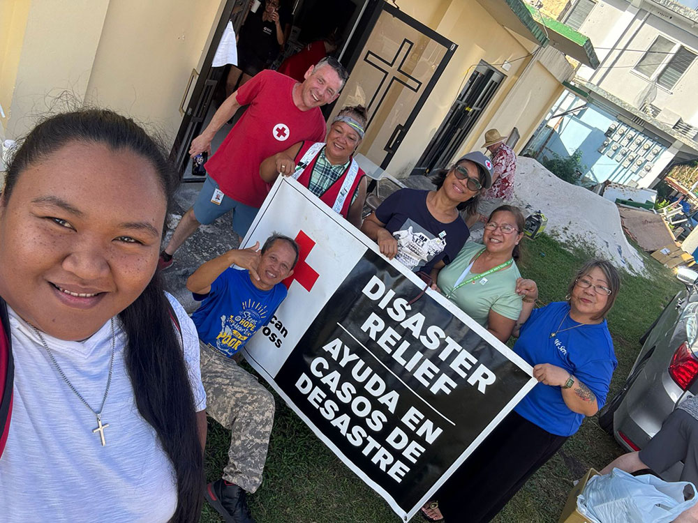 A diverse group of individuals holding a sign that reads "Disaster Relief," advocating for support and assistance.