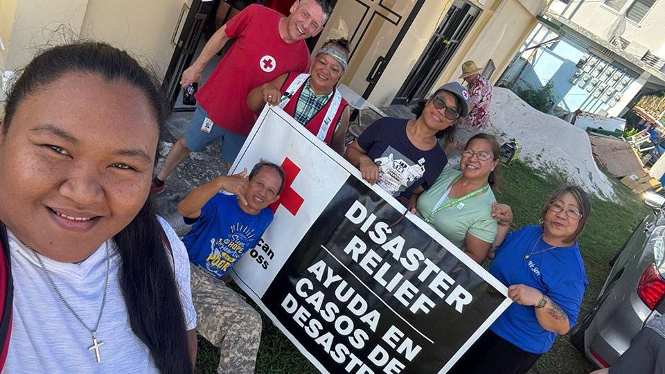 A diverse group of individuals holding a sign that reads "Disaster Relief," advocating for support and assistance.
