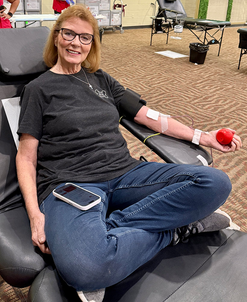 Diane Holmes sitting in chair and donating blood.
