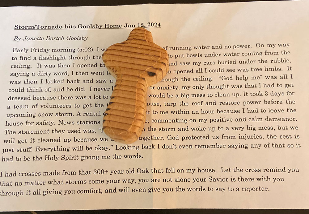 small oak wooden cross sitting on top of a news article.