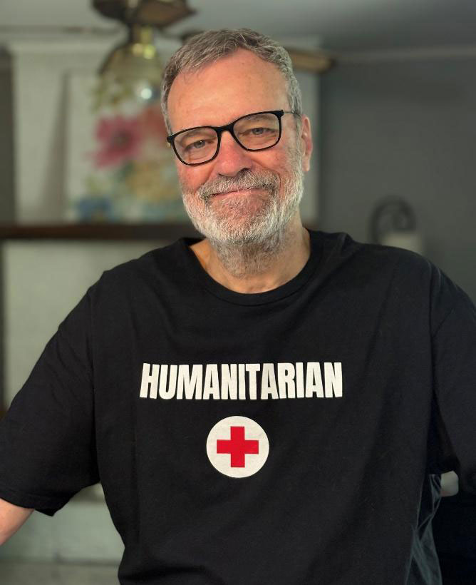 Michael Bowman wearing glasses and a Red Cross shirt.