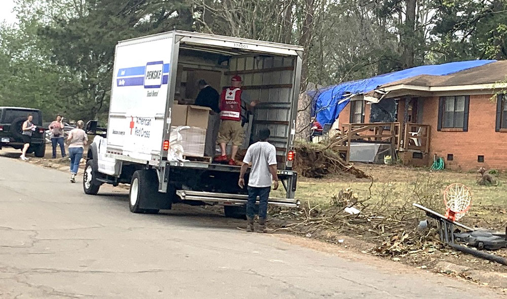 Red Cross volunteers in moving truck hand out disaster emergency supplies