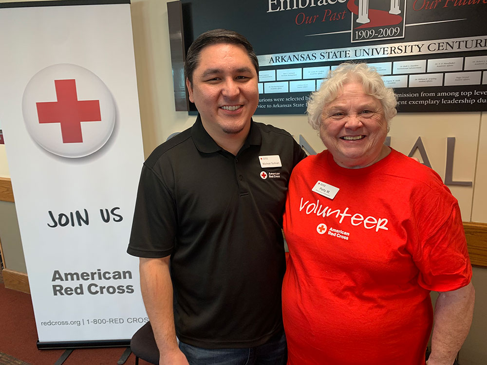 Patty Minga next to Micheal Sullivan, wearing their Red Cross shirts.