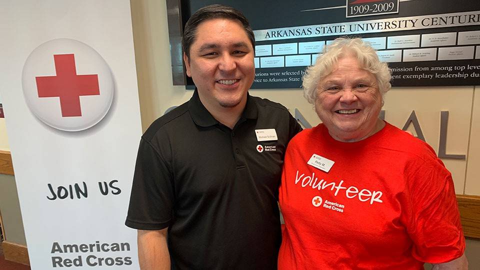 Patty Minga next to Micheal Sullivan, wearing their Red Cross shirts.