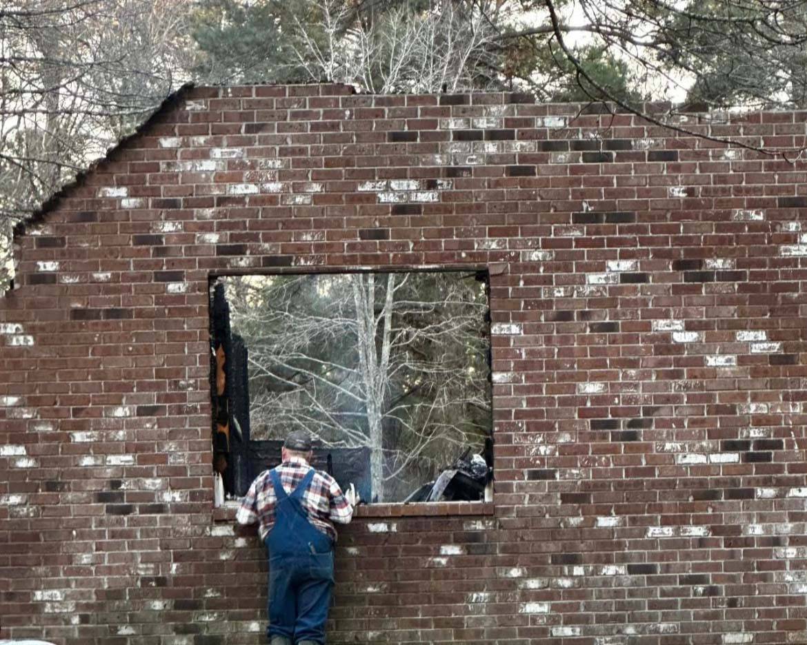 Robert Coleman looks at what is left of his home after the devastating fire