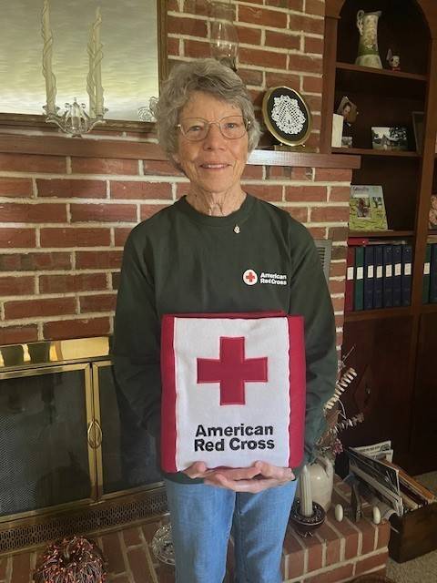 pearl gruenke holding red cross pillow