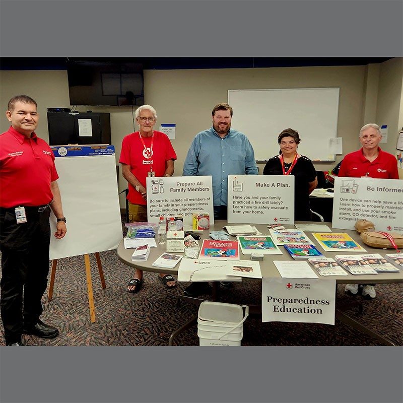 Red Cross volunteers pose with items for volunteer fairs.